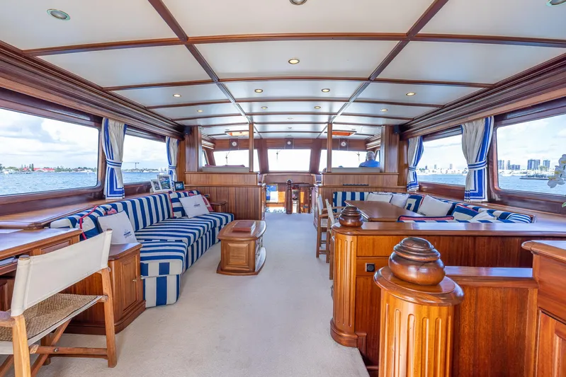 Essence Yacht Photos Pics Luxurious interior of 2006 Vicem 85 Classic yacht with elegant woodwork and striped seating.