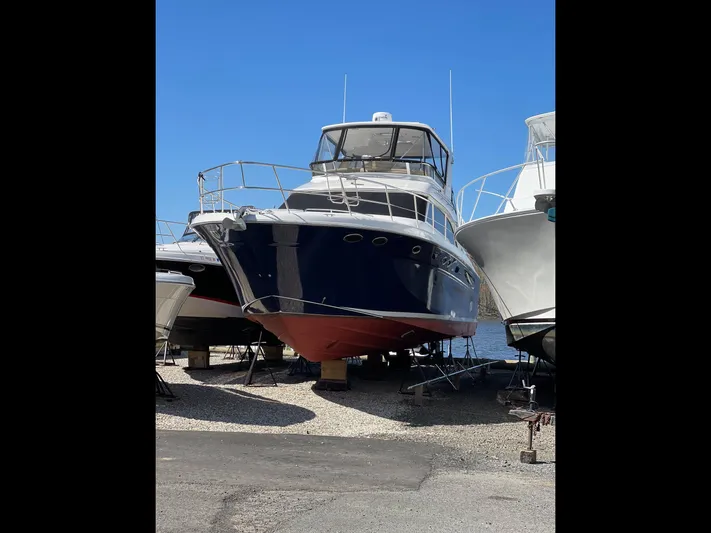 Another Chapter Yacht Photos Pics 1999 Sea Ray 480 Sedan Bridge yacht on dry dock, blue hull, clear sky background.