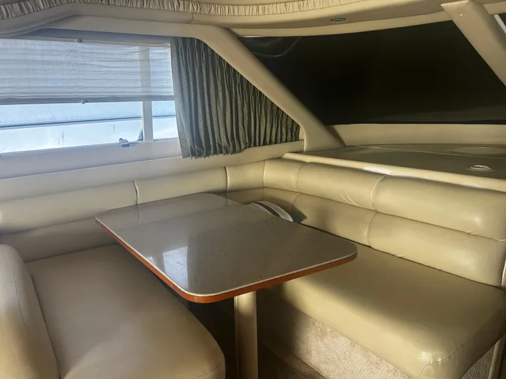 Another Chapter Yacht Photos Pics Interior of 1999 Sea Ray 480 Sedan Bridge with beige leather seating and table.