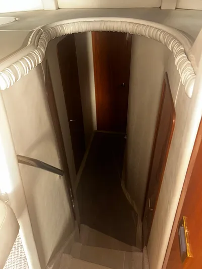 Another Chapter Yacht Photos Pics Interior staircase of 1999 Sea Ray 480 Sedan Bridge yacht, featuring wooden doors and carpeted steps.
