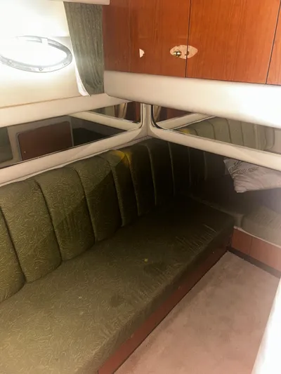 Another Chapter Yacht Photos Pics Interior of 1999 Sea Ray 480 Sedan Bridge with green upholstered seating and wooden cabinetry.