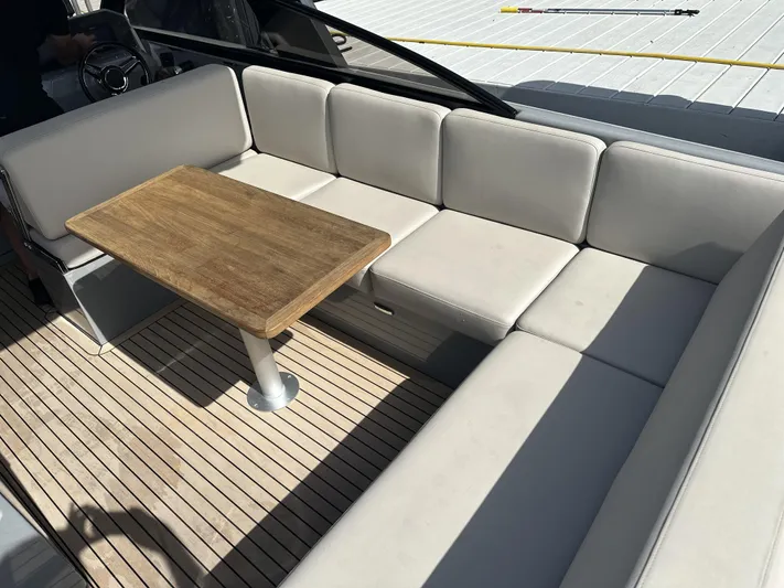 Rand Leisure 28 Yacht Photos Pics Luxurious seating area on 2021 Rand Leisure boat with wooden table and cushioned seats.