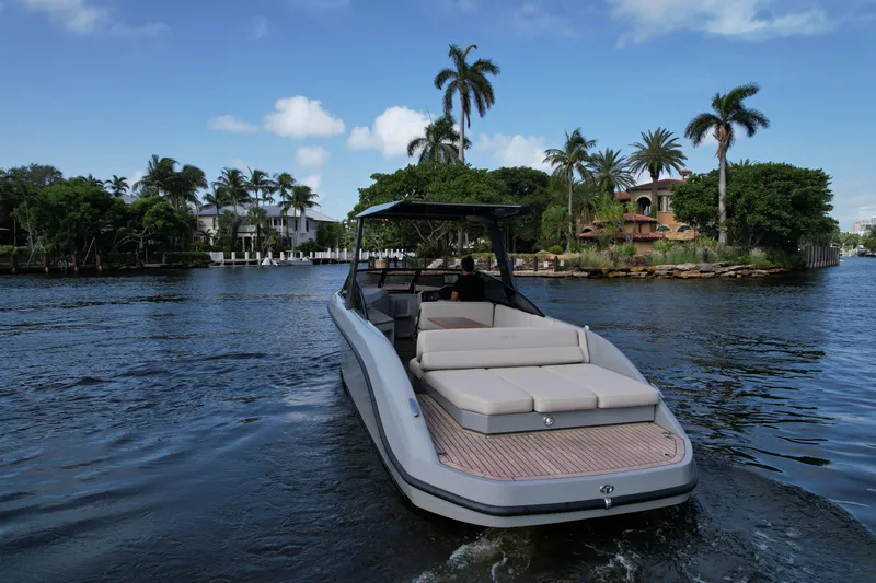 Rand Leisure 28 Yacht Photos Pics 2021 Rand Leisure boat cruising on a scenic, palm-lined waterway.