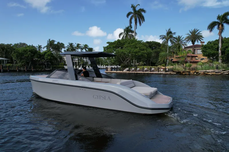 Rand Leisure 28 Yacht Photos Pics 2021 Rand Leisure boat cruising on a scenic waterway with palm trees.