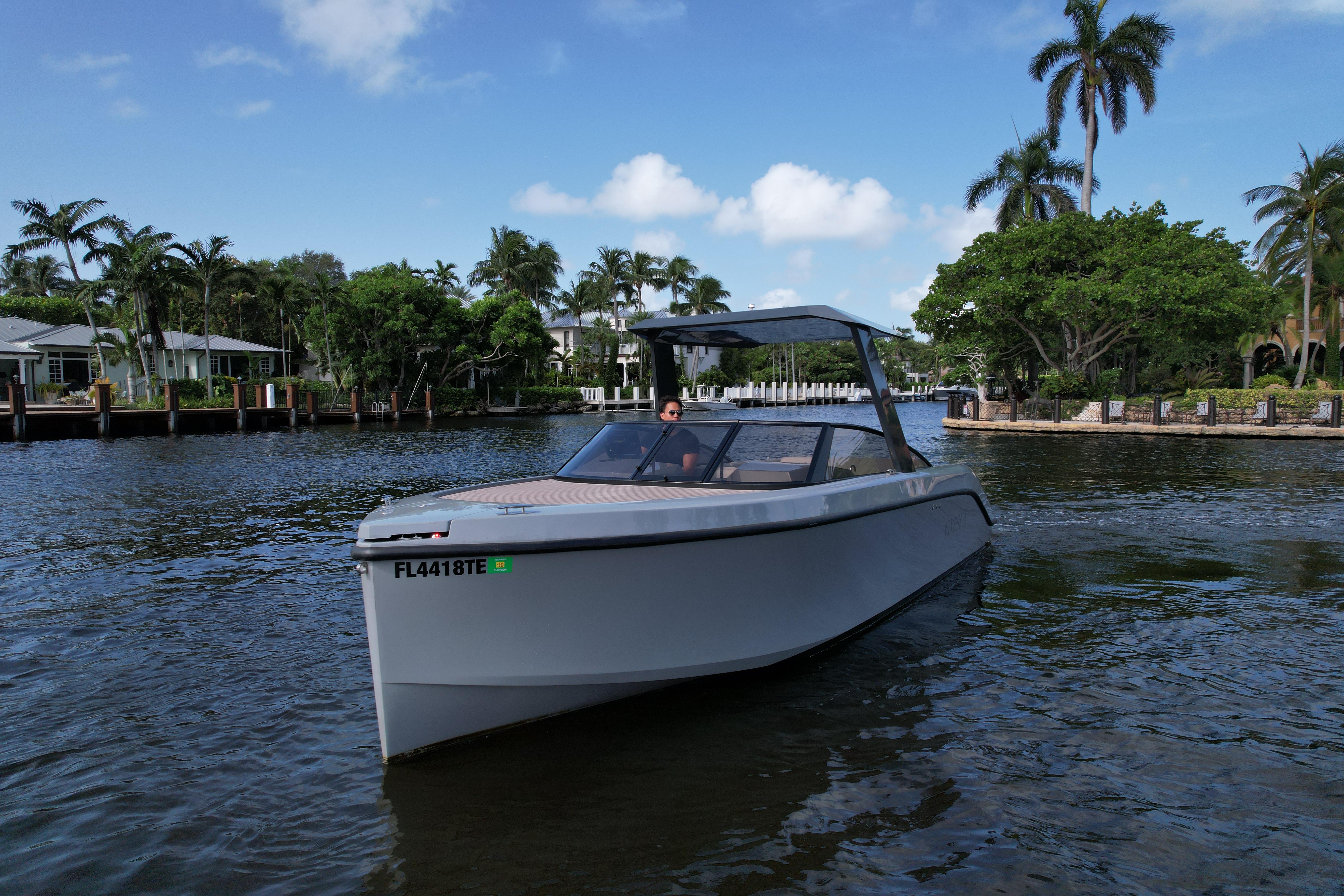 Modern 2021 Rand Leisure boat cruising on a scenic waterway with palm trees.