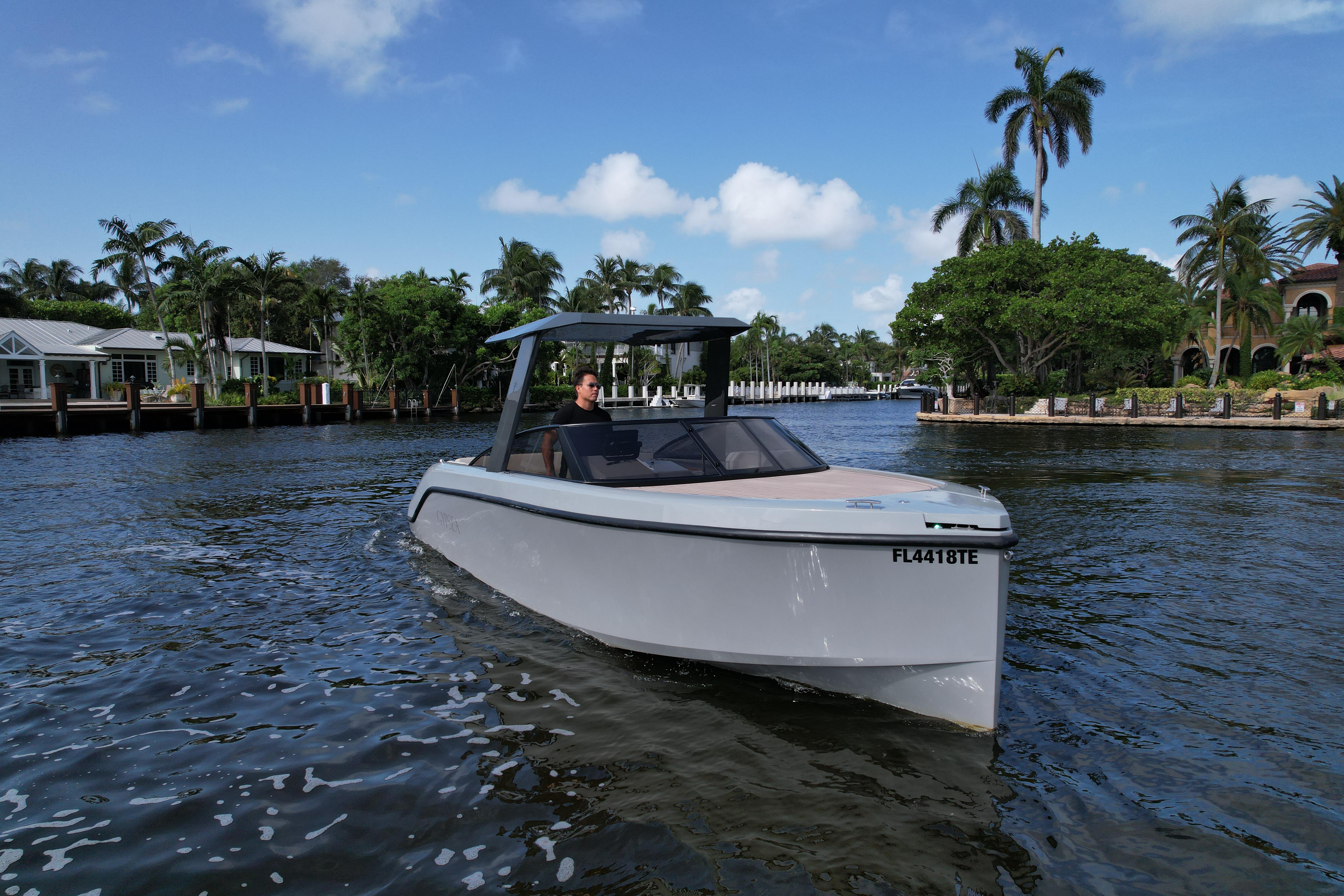 2021 Rand Leisure boat cruising on a scenic waterway with palm trees and houses.