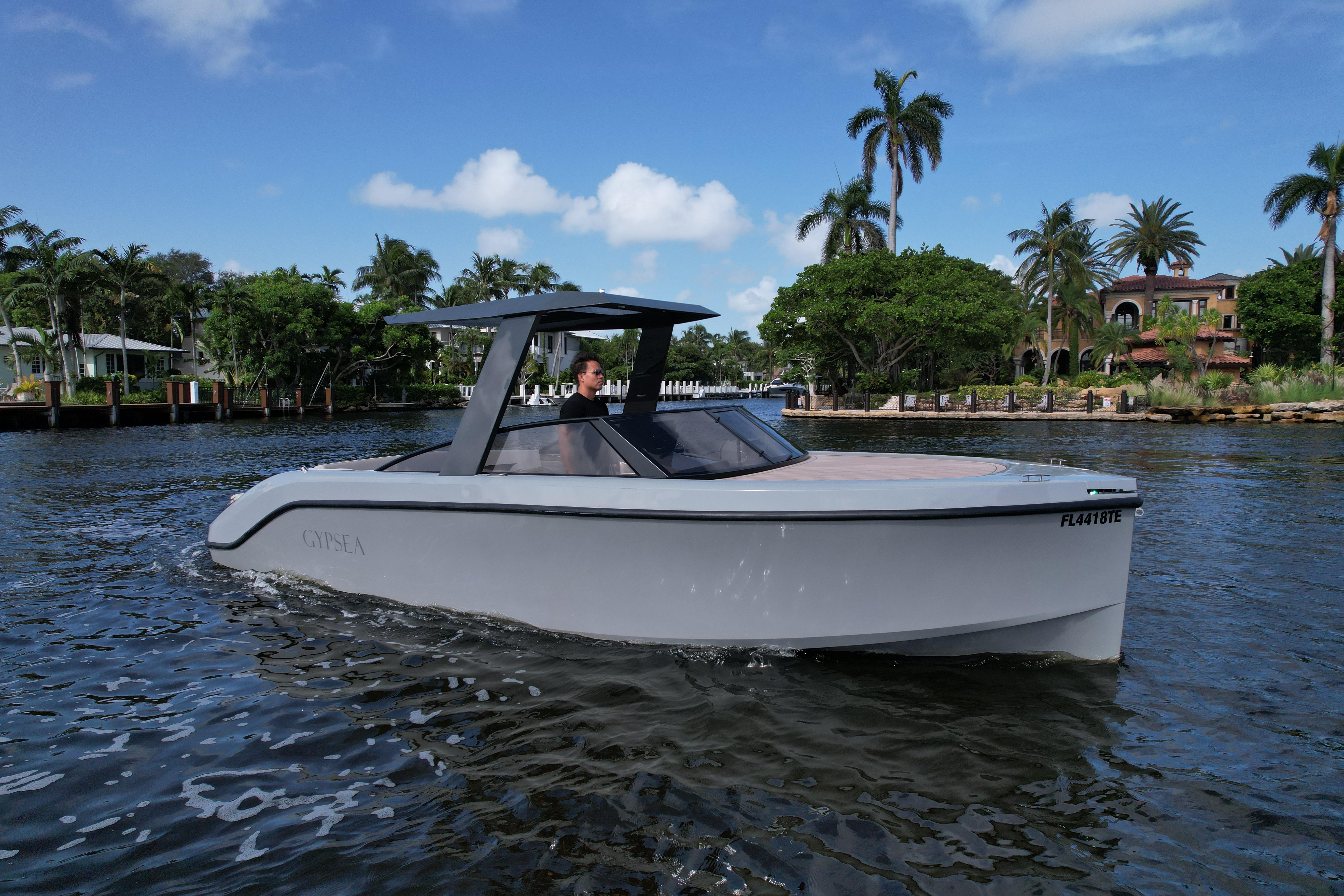 Modern 2021 Rand Leisure boat cruising on a scenic waterway with palm trees.