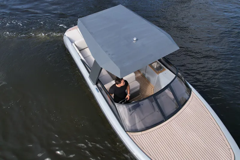 Rand Leisure 28 Yacht Photos Pics 2021 Rand Leisure boat cruising on water with a canopy and seating area.