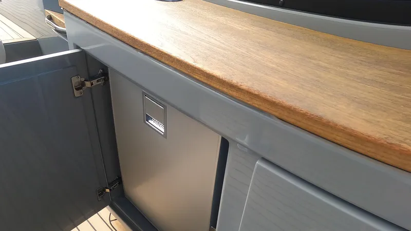 Rand Leisure 28 Yacht Photos Pics 2021 Rand Leisure boat interior with wooden countertop and open storage compartment.