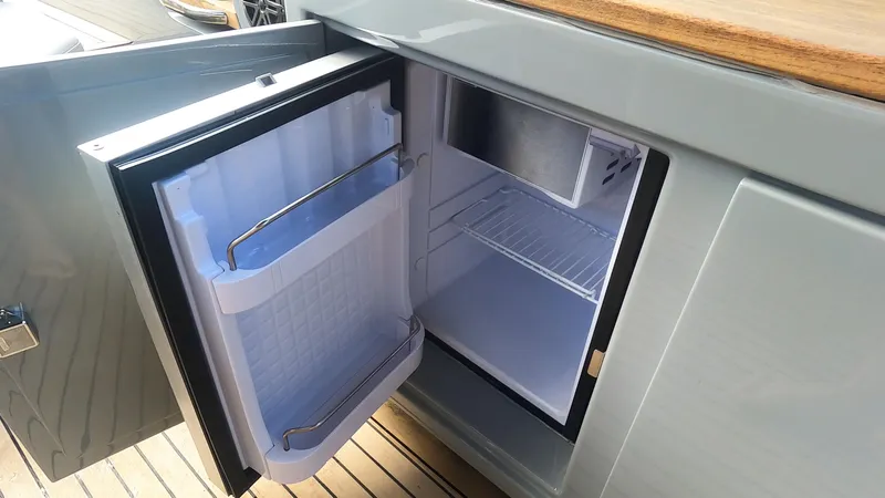Rand Leisure 28 Yacht Photos Pics Open mini fridge on Rand Leisure 2021 boat, showcasing interior storage space.