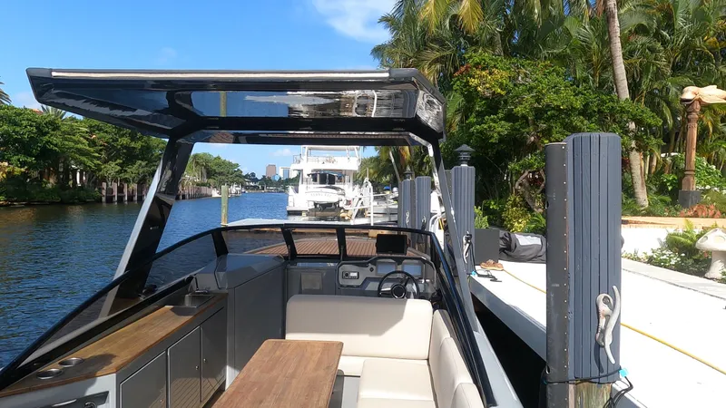 Rand Leisure 28 Yacht Photos Pics 2021 Rand Leisure boat docked by a scenic waterfront with lush greenery.