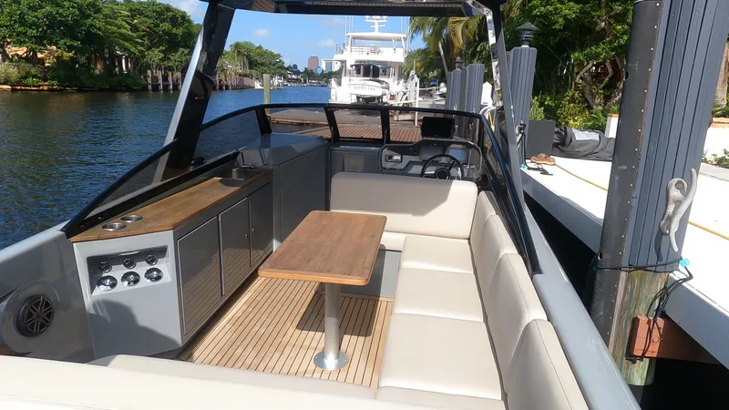 Rand Leisure 28 Yacht Photos Pics Luxurious 2021 Rand Leisure boat with spacious seating and elegant wooden table on a sunny day.