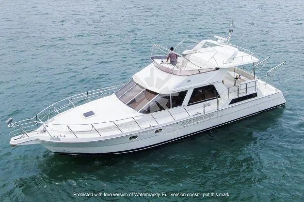 2002 Vitech 58 yacht cruising on open water, featuring sleek design and spacious deck.