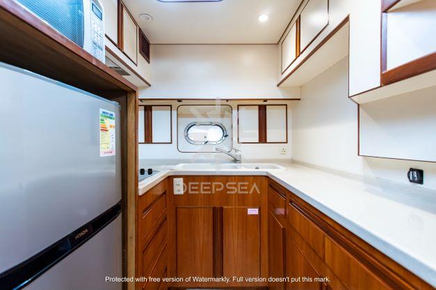 Luxurious kitchen interior of 2002 Vitech 58 yacht with wooden cabinetry and modern appliances.
