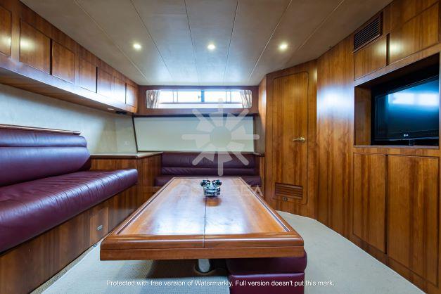 Luxurious interior of 2002 Vitech 58 yacht with wood paneling and leather seating.