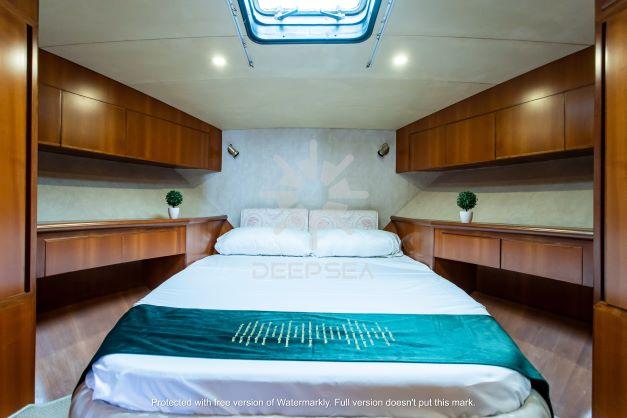 Luxurious Vitech 58 yacht bedroom interior, 2002 model, featuring elegant wood cabinetry and skylight.
