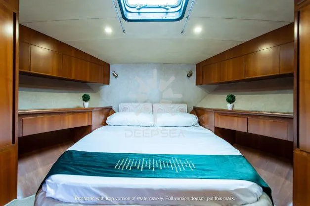 Luxurious Vitech 58 yacht bedroom interior, 2002 model, featuring elegant wood cabinetry and skylight.