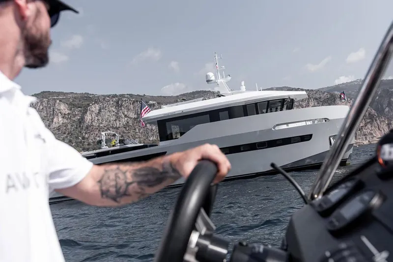 Crossover 27 #1 Yacht Photos Pics 2024 Lynx Crossover 27 yacht on water, viewed from a nearby boat, with scenic cliffs.