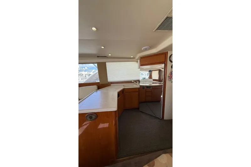  Yacht Photos Pics Interior of 1999 Viking 50 Convertible yacht with modern kitchen and wooden cabinetry.