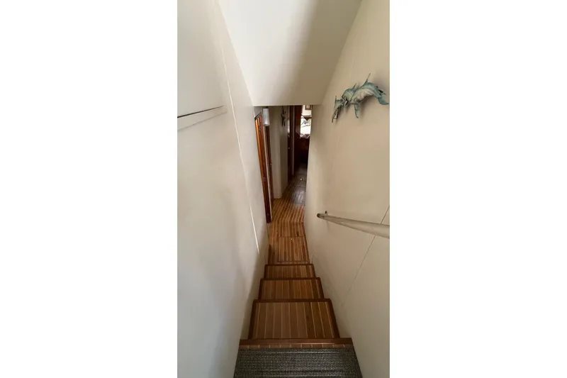  Yacht Photos Pics Stairway inside 1999 Viking 50 Convertible yacht with wooden flooring and wall decor.