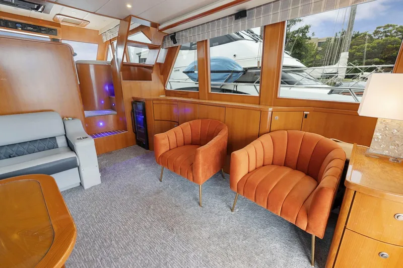Yachtmaster Yacht Photos Pics Luxurious yacht interior with orange chairs, wood paneling, and large windows, Symbol 58, 2002 model.