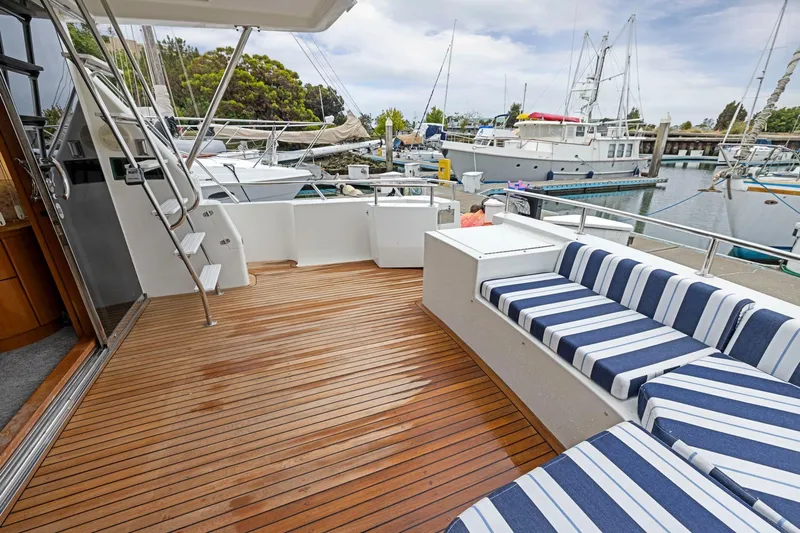 Yachtmaster Yacht Photos Pics Spacious deck of 2002 Symbol 58 yacht with striped seating, docked at marina.