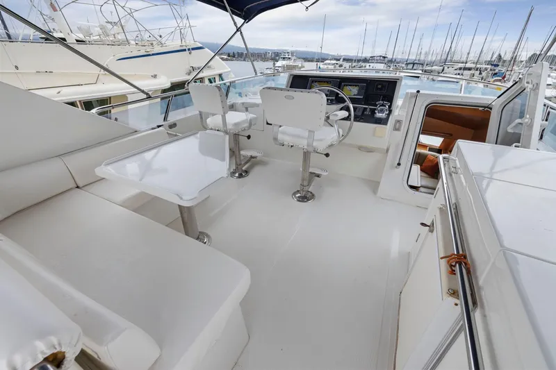 Yachtmaster Yacht Photos Pics Luxurious 2002 Symbol 58 yacht cockpit with seating, table, and helm at marina.