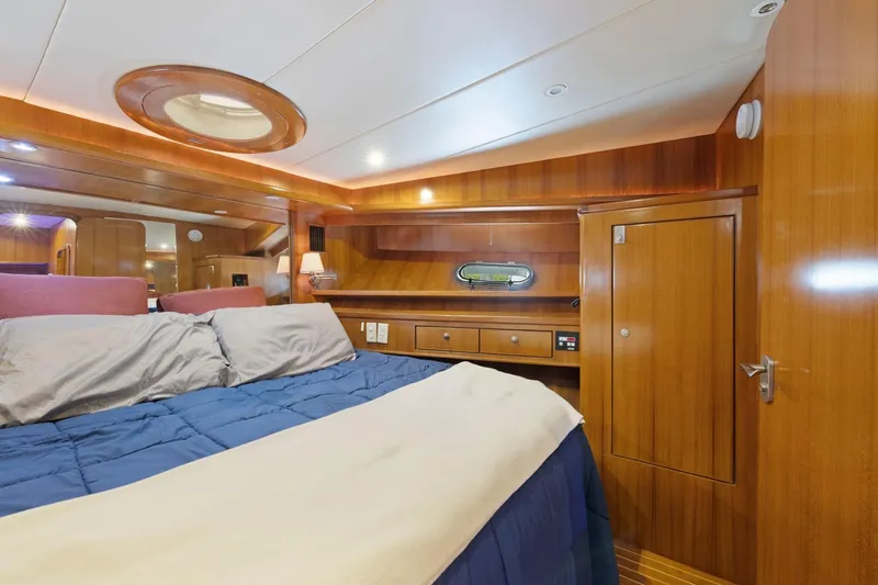 Yachtmaster Yacht Photos Pics Luxurious wooden cabin interior of a 2002 Symbol 58 yacht with cozy bedding.
