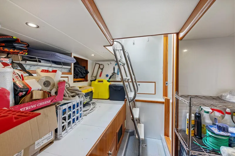 Yachtmaster Yacht Photos Pics Storage area in a 2002 Symbol 58 yacht with ladder, shelves, and various supplies.