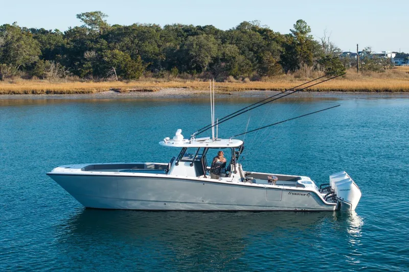 Full Send Yacht Photos Pics 2024 Freeman 38 boat on calm water, surrounded by lush greenery.