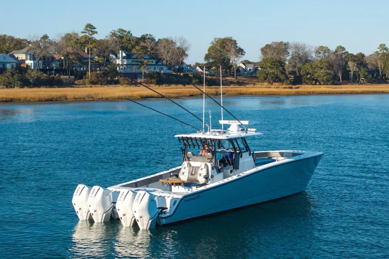 Full Send Yacht Photos Pics 2024 Freeman 38 boat on calm water near a scenic shoreline.