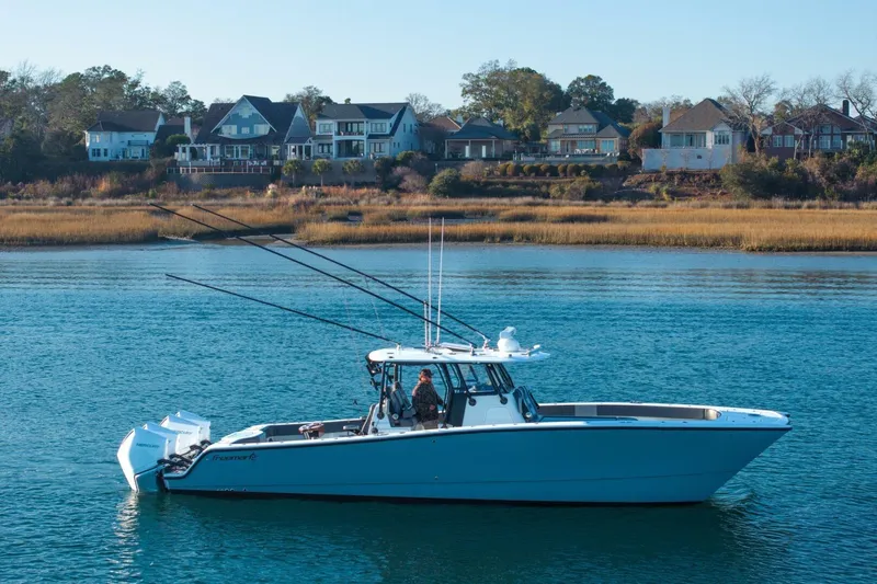 Full Send Yacht Photos Pics 2024 Freeman 38 boat on calm water with houses in the background.
