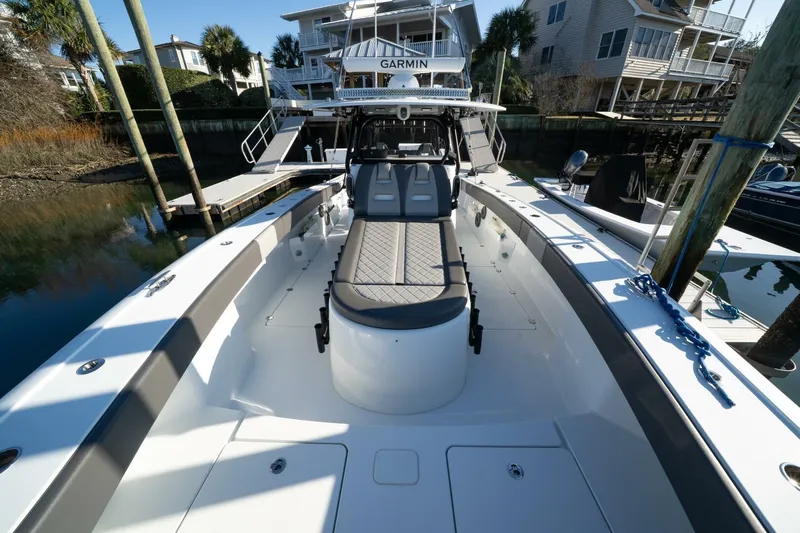 Full Send Yacht Photos Pics 2024 Freeman 38 boat with spacious deck, docked near waterfront homes.