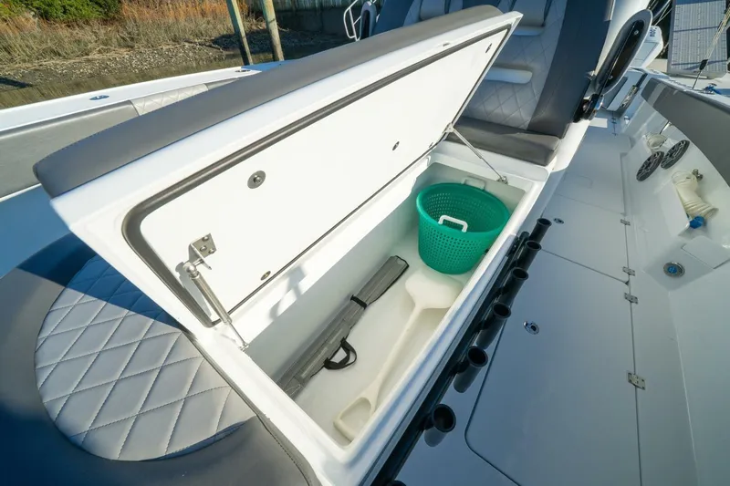 Full Send Yacht Photos Pics 2024 Freeman 38 boat storage compartment with green basket and seating area.