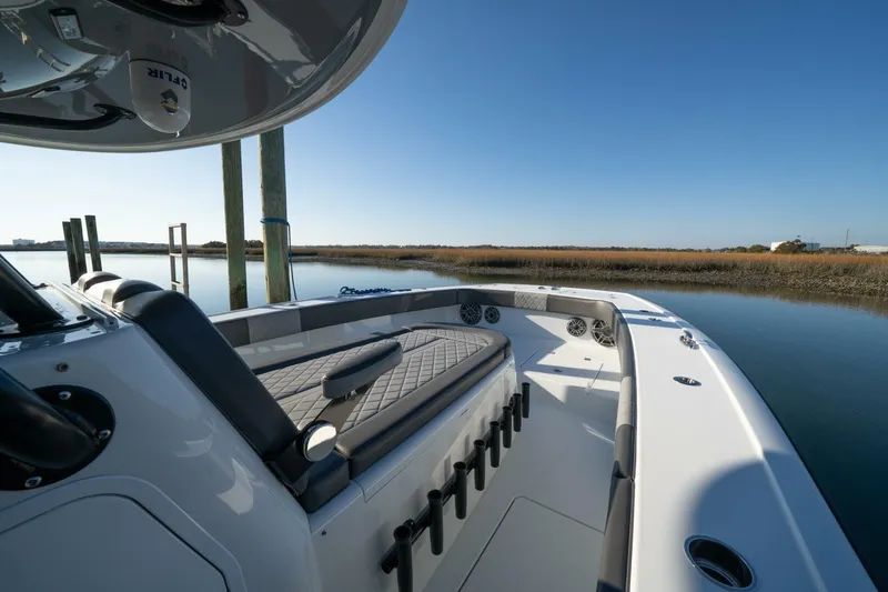 Full Send Yacht Photos Pics 2024 Freeman 38 boat interior with seating, docked by calm waters under clear blue sky.