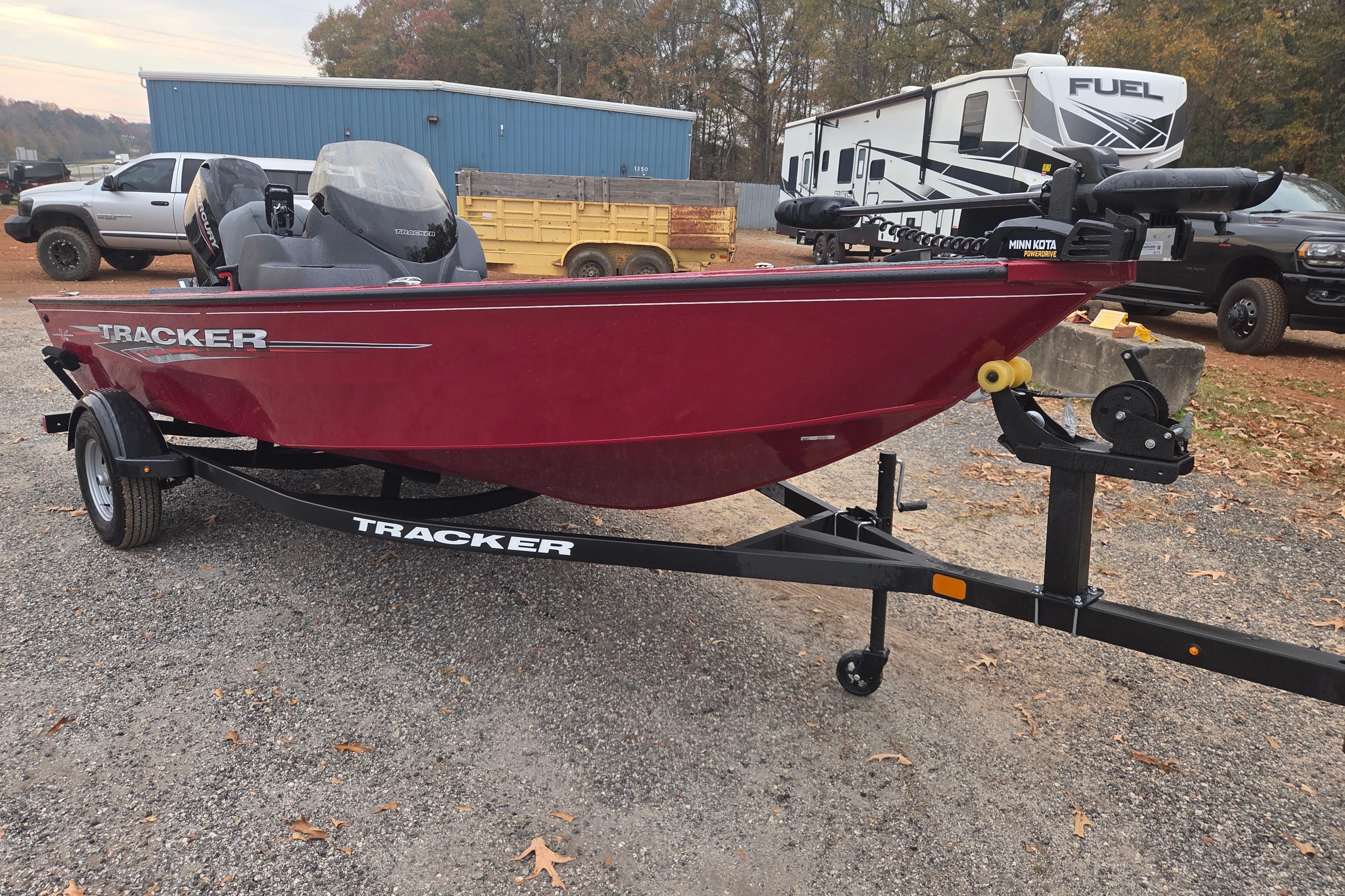 2025 Tracker Super Guide V-16 SC boat on trailer, parked outdoors.