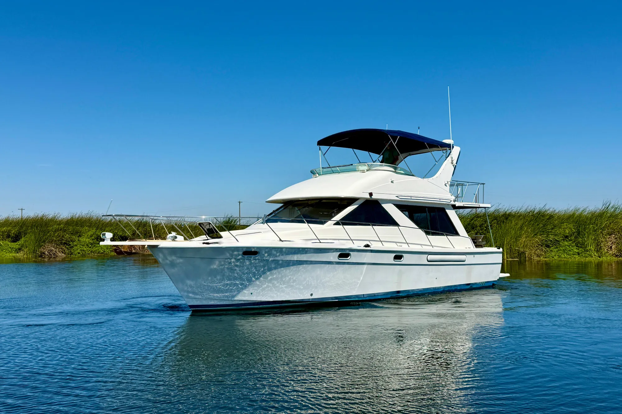1998 Bayliner 3988 Command Bridge Motoryacht cruising on a calm, sunny waterway.