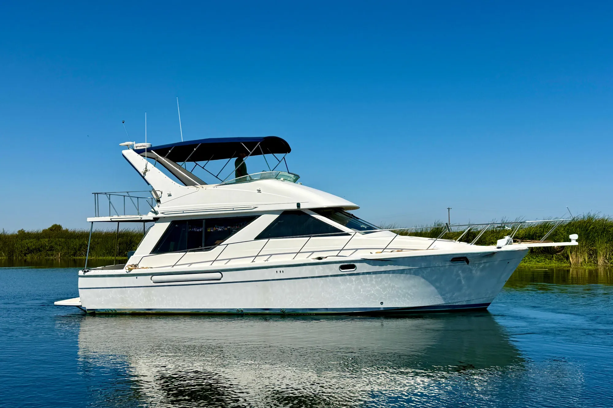 1998 Bayliner 3988 Command Bridge Motoryacht on calm water under clear blue sky.