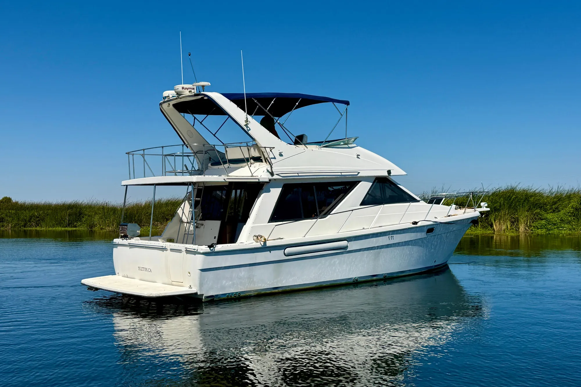 1998 Bayliner 3988 Command Bridge Motoryacht on calm water under clear blue sky.
