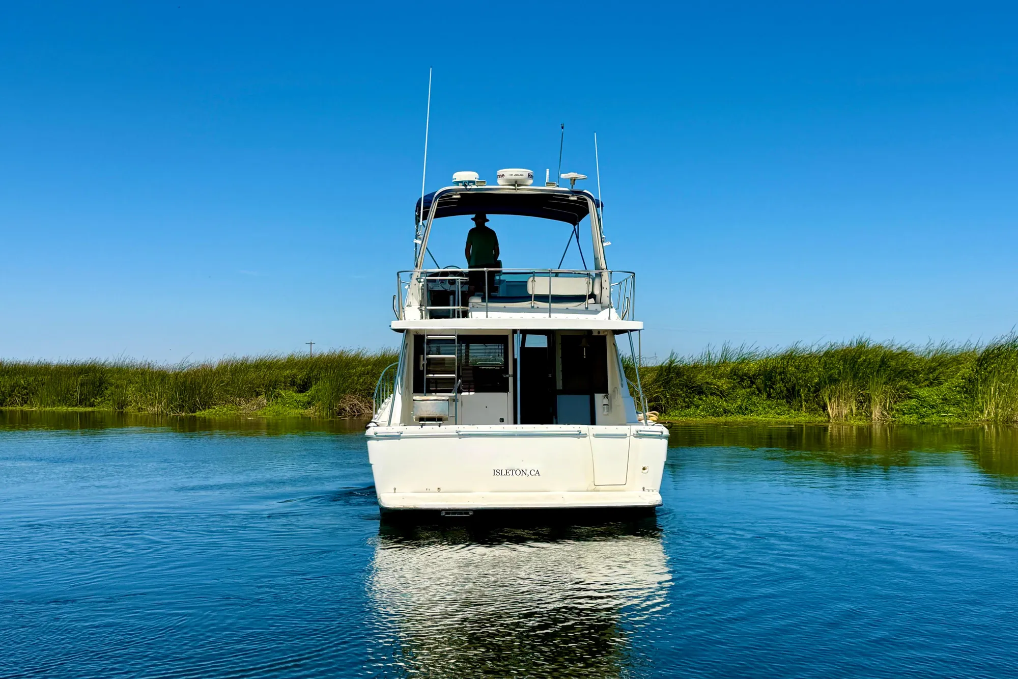 1998 Bayliner 3988 Command Bridge Motoryacht on calm water under clear blue sky.