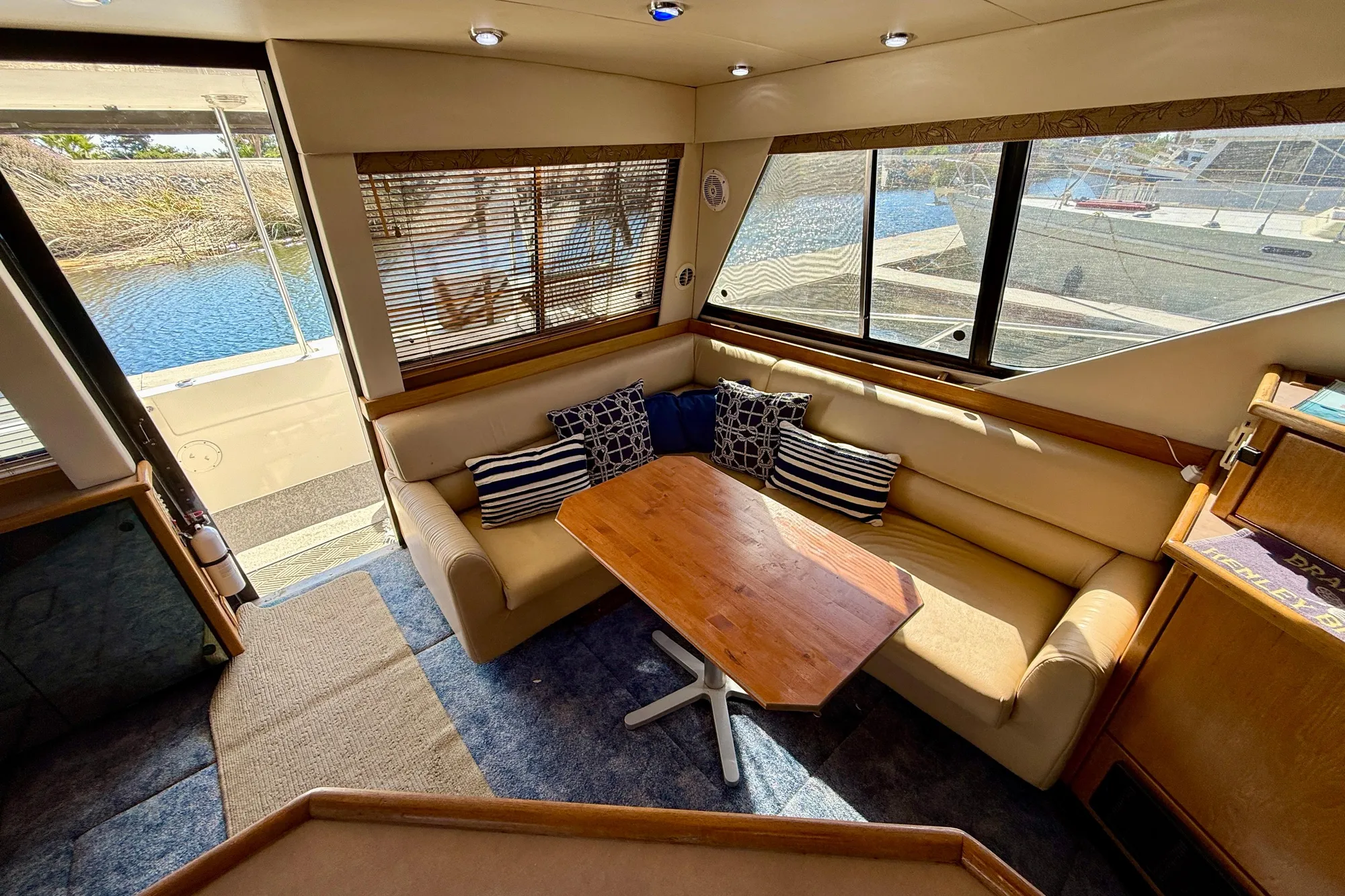 Luxurious interior of 1998 Bayliner 3988 Command Bridge Motoryacht with cozy seating and wooden table.