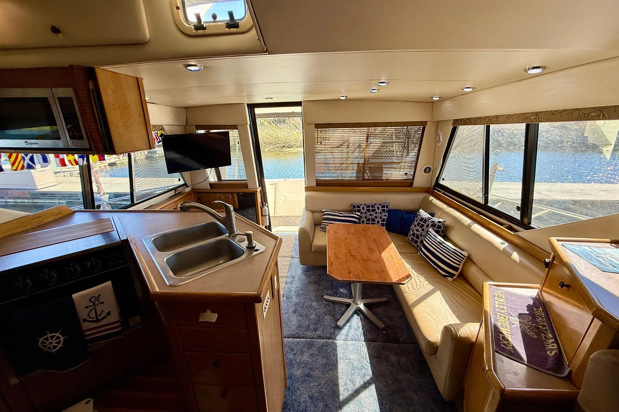 Luxurious interior of 1998 Bayliner 3988 Command Bridge Motoryacht with seating and kitchenette.