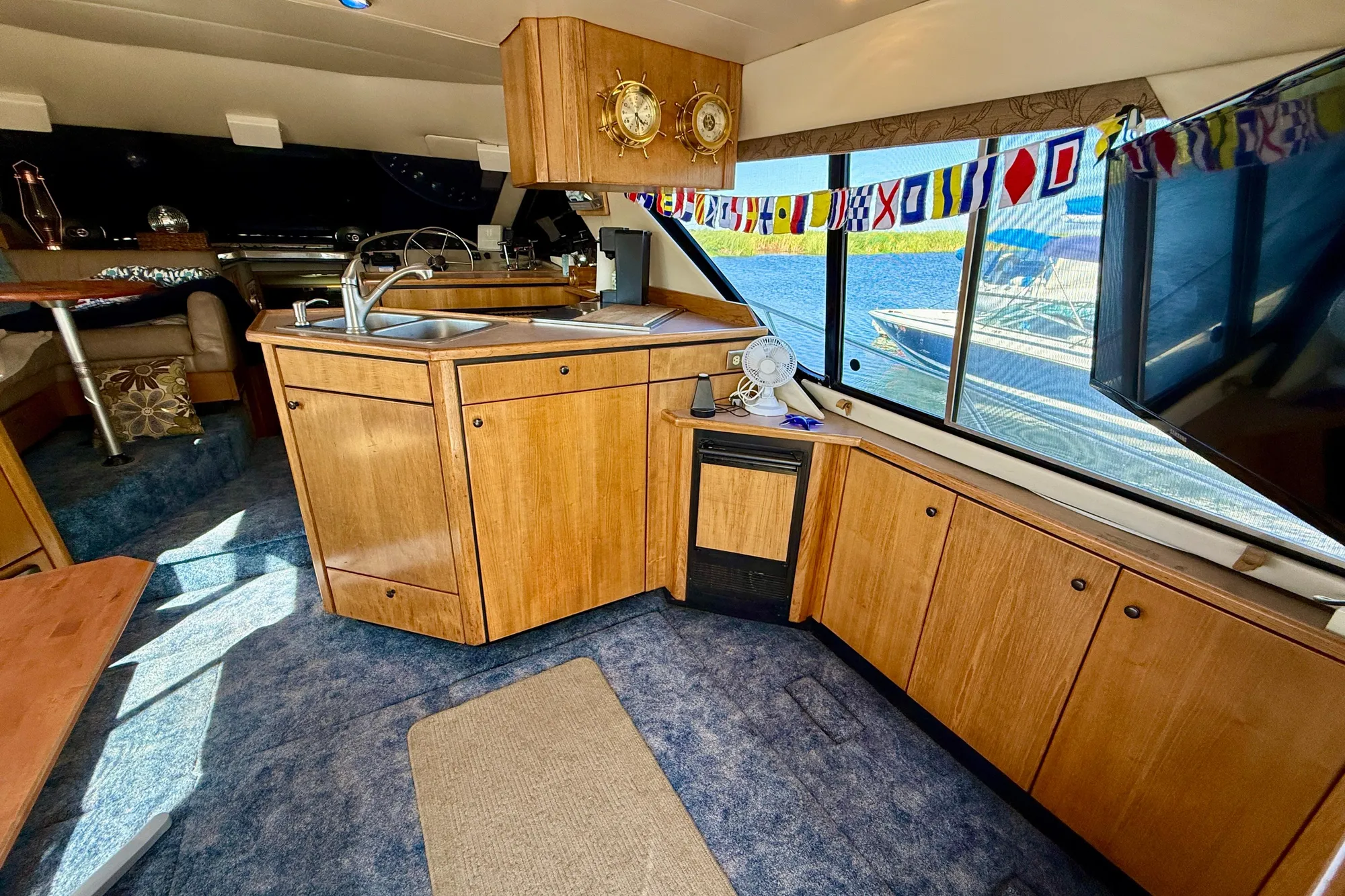 Interior of 1998 Bayliner 3988 Command Bridge Motoryacht with wooden cabinetry and nautical decor.