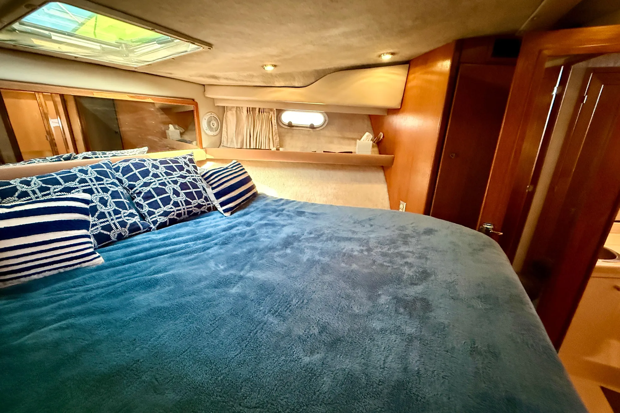 Cozy bedroom in 1998 Bayliner 3988 Command Bridge Motoryacht with nautical-themed decor.