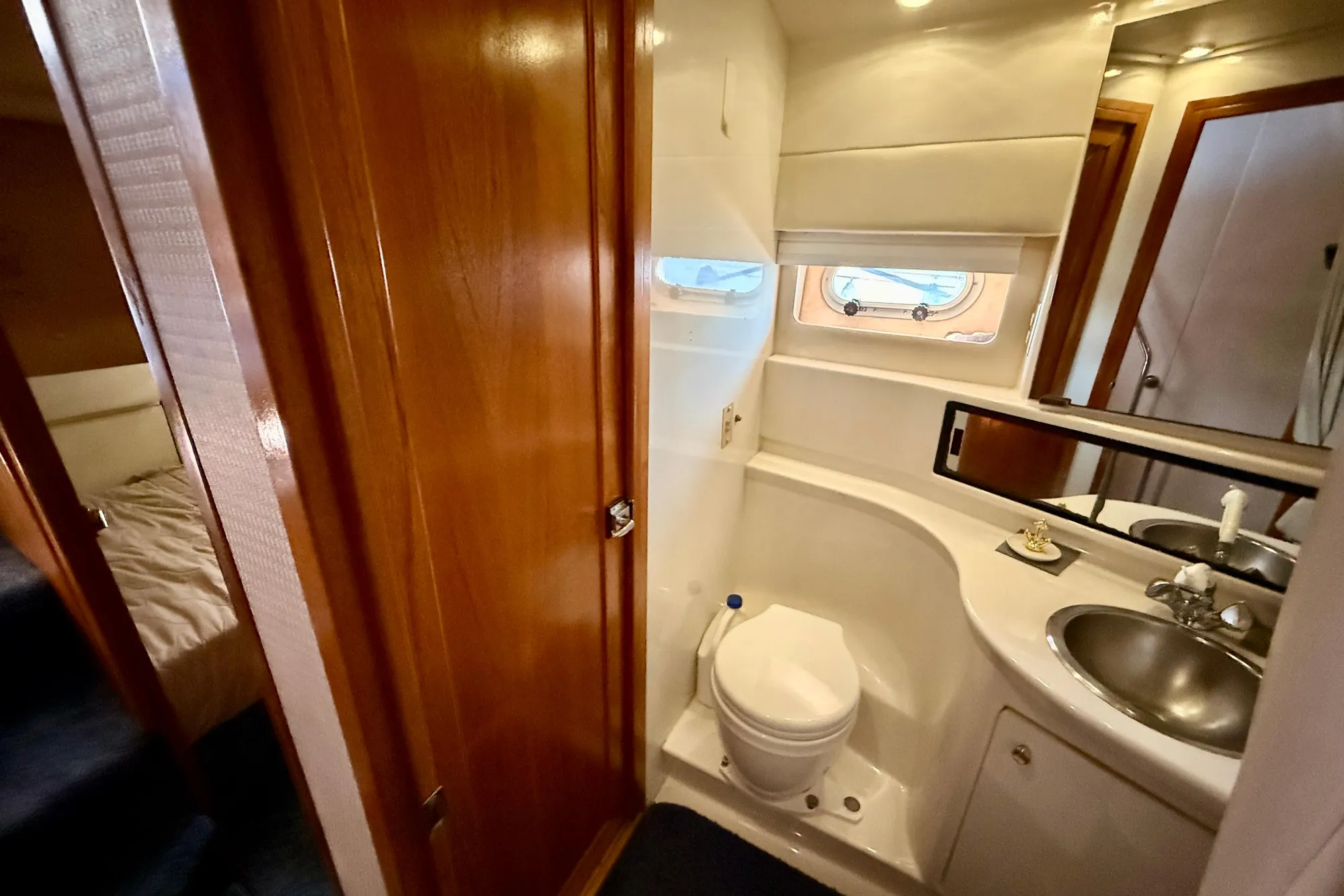 1998 Bayliner 3988 Command Bridge Motoryacht bathroom with sink, toilet, and mirror.