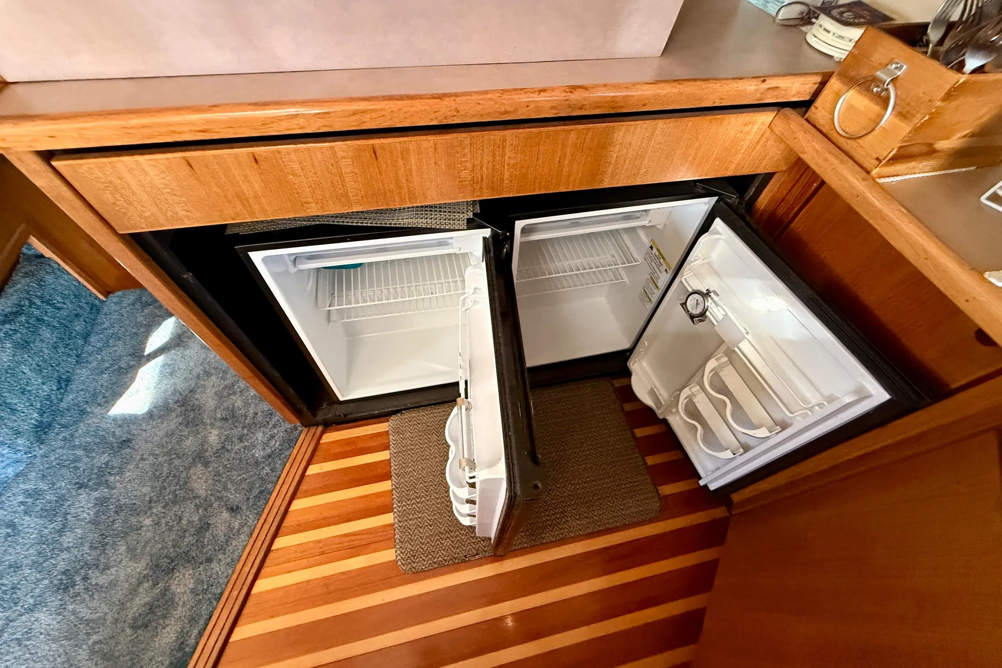 1998 Bayliner 3988 Command Bridge Motoryacht interior with open fridge, wooden flooring.