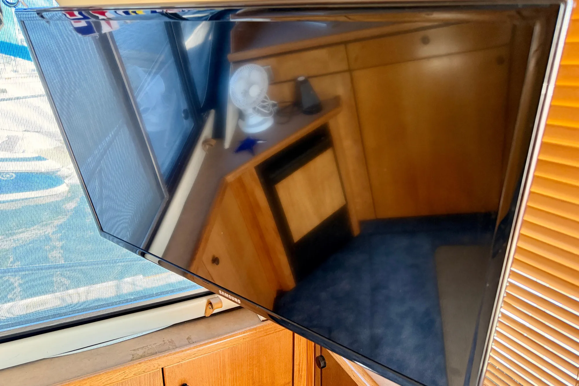 1998 Bayliner 3988 Command Bridge Motoryacht interior with TV and wooden cabinetry.