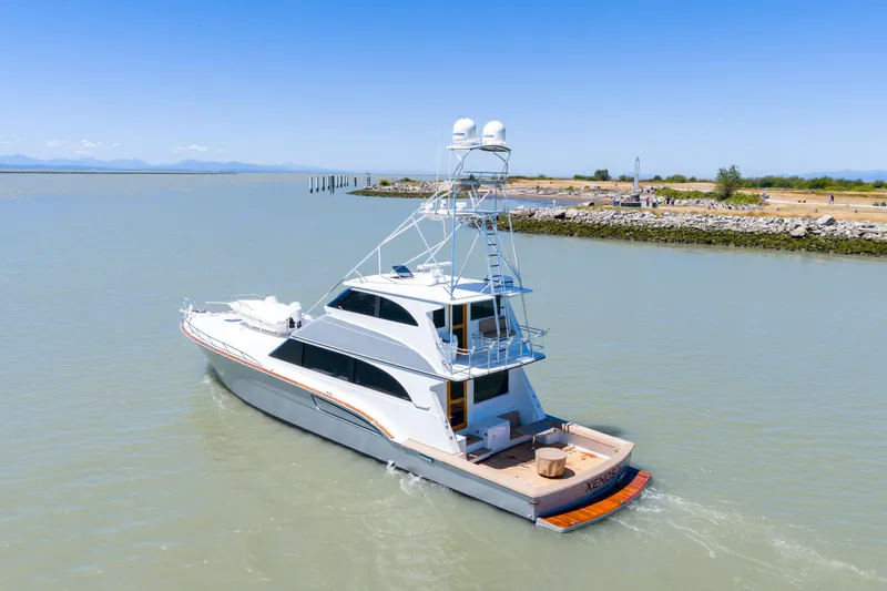  Yacht Photos Pics 1998 Donzi R73 yacht cruising in calm waters near a rocky shoreline.