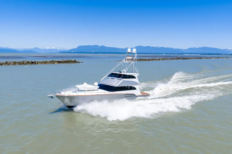  Yacht Photos Pics 1998 Donzi R73 yacht cruising on open water with mountains in the background.
