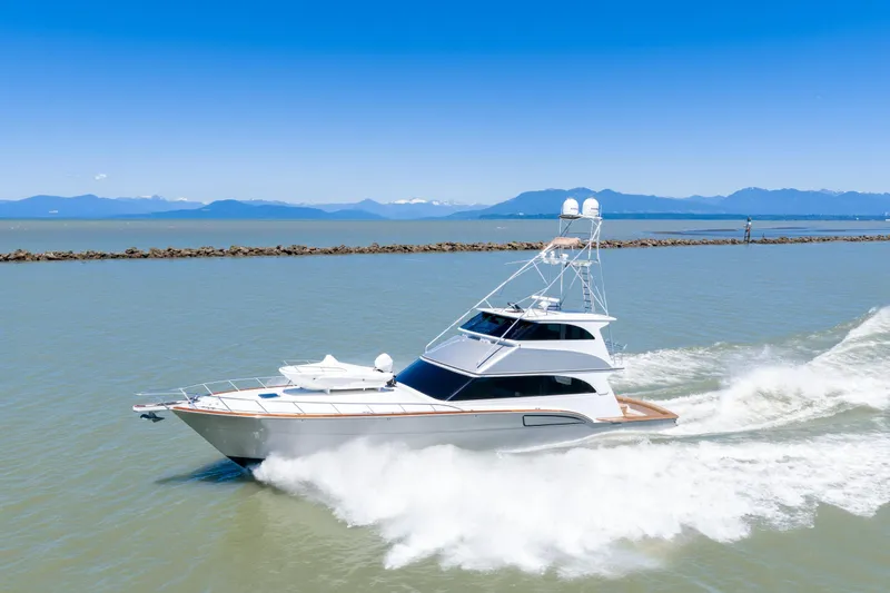  Yacht Photos Pics 1998 Donzi R73 yacht cruising on open water with scenic mountain backdrop.